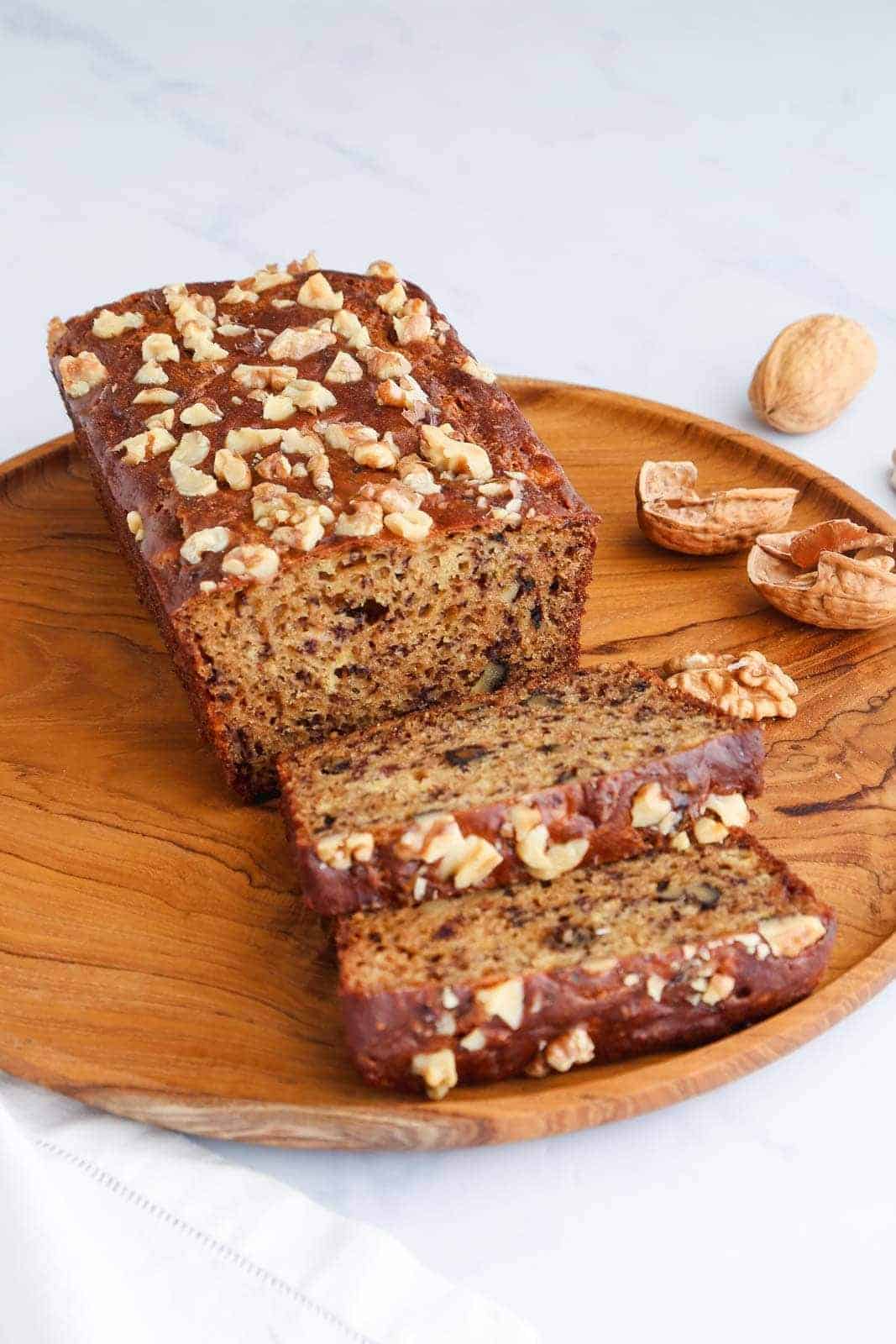 Delicious banana walnut bread served on w wooden plate.