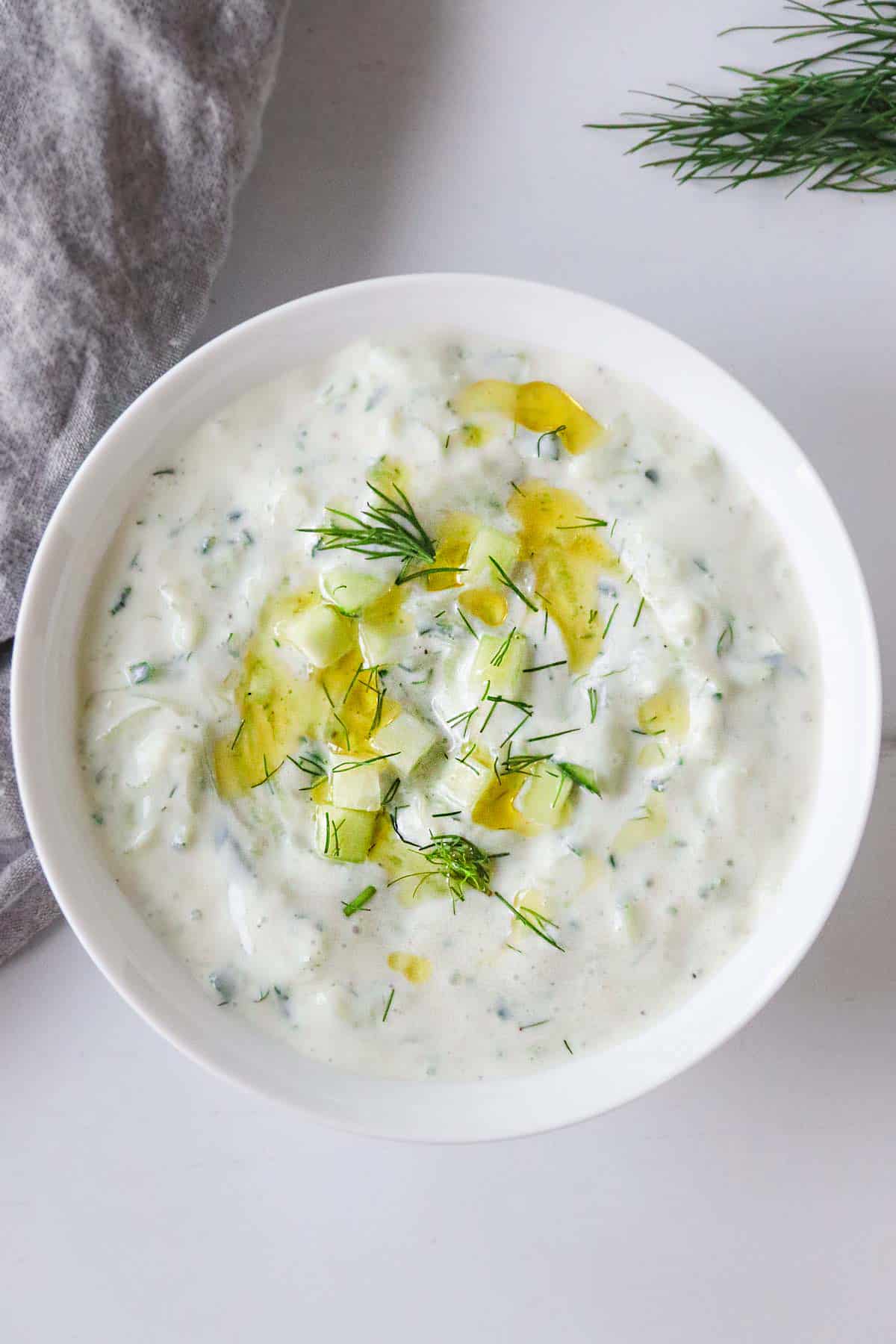 Vegan Tzatziki in a white bowl topped with fresh dill