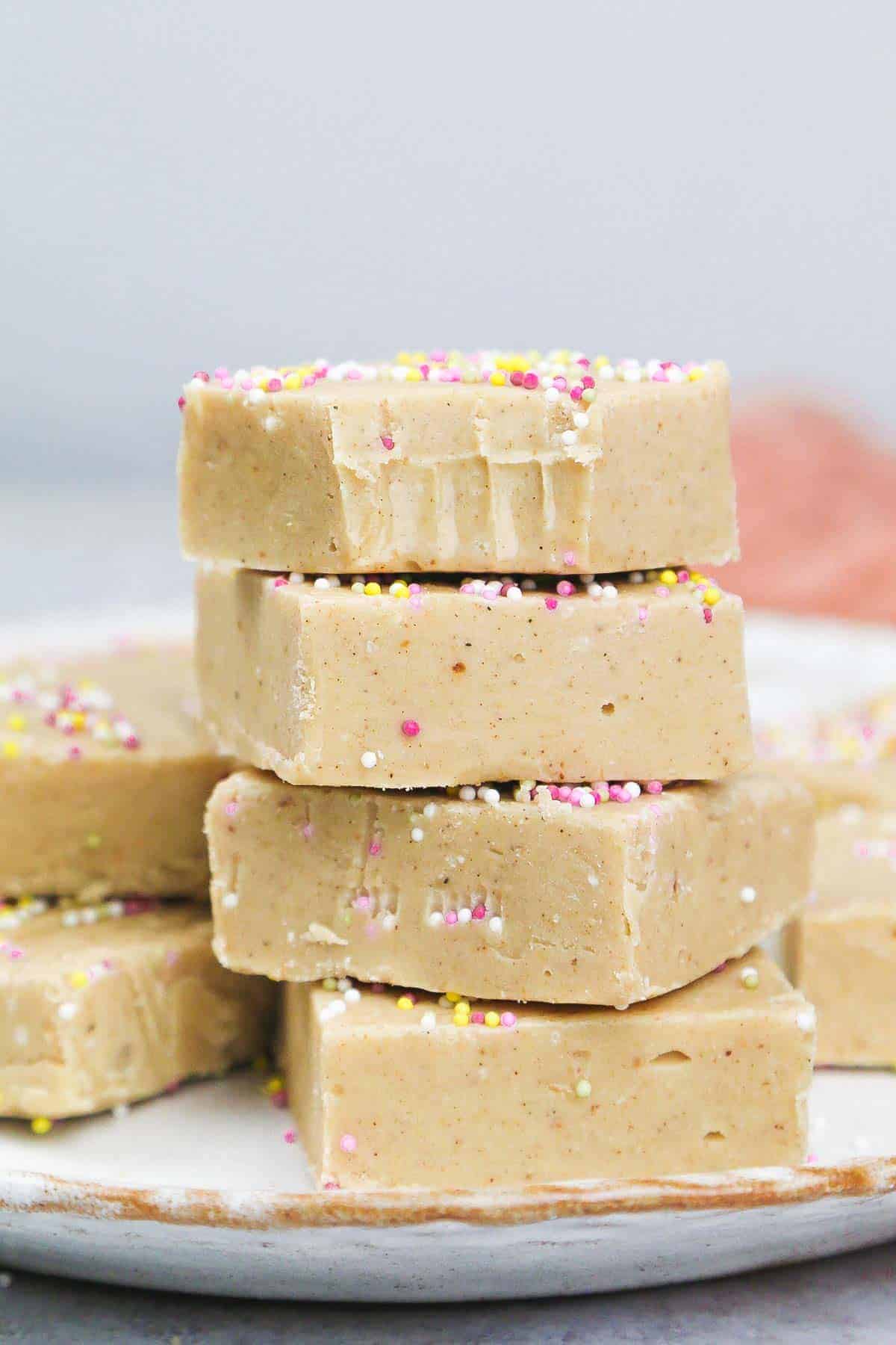 A close up shot of stacked Condensed Milk Fudge squares on a plate