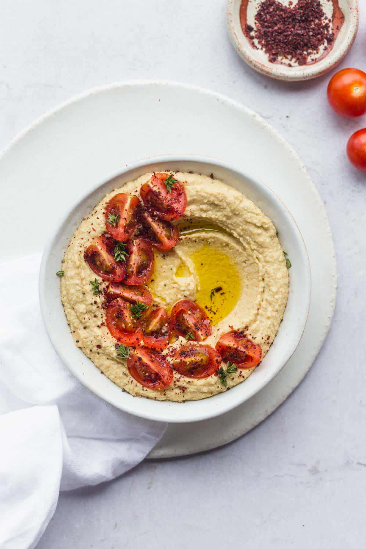 Hummus served in a bowl and decorated with cherry tomatoes