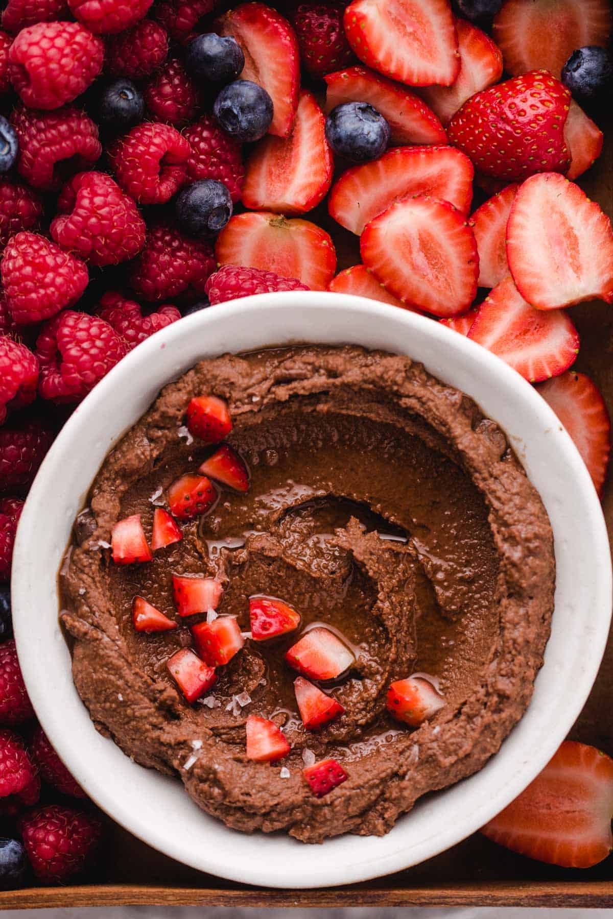Brownie Batter Hummus garnished with maple syrup and strawberries