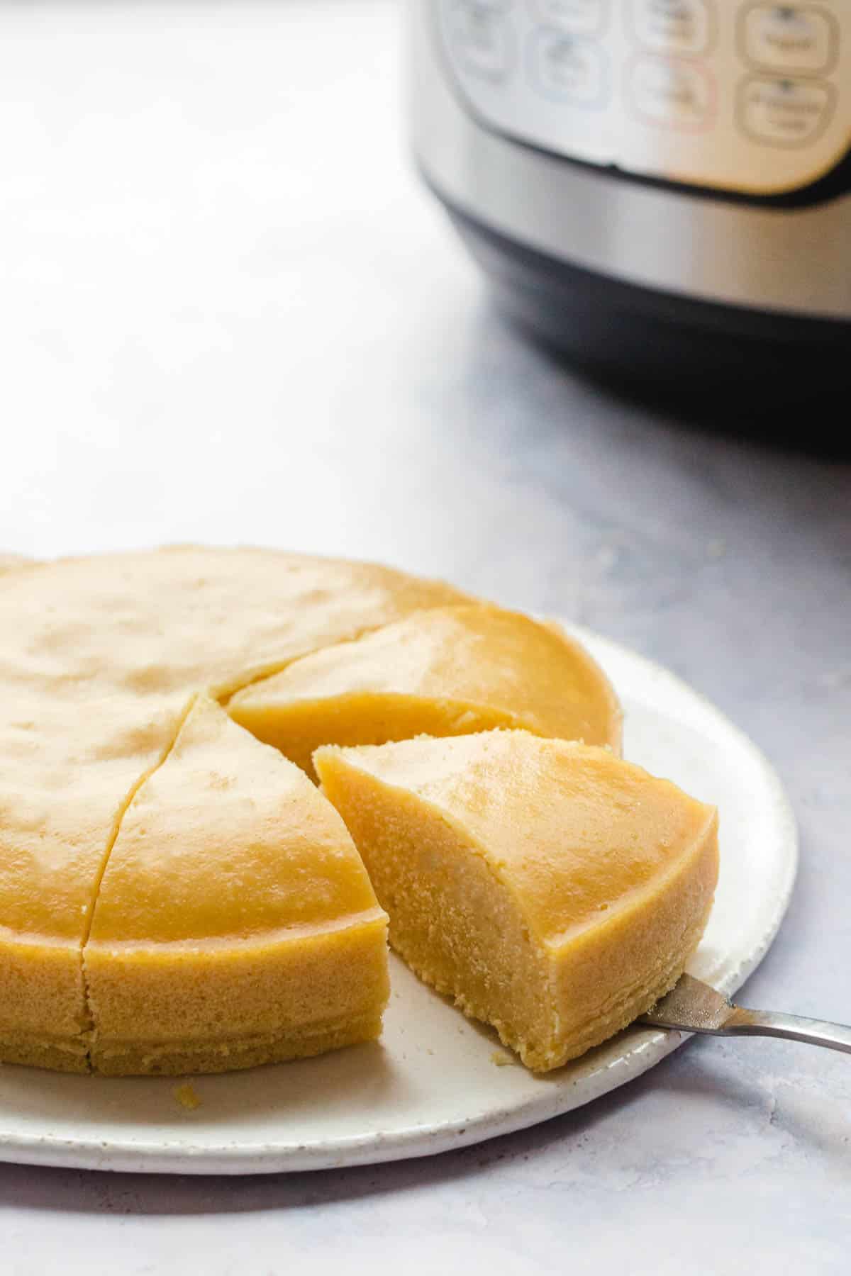 Sliced Instant Pot Cornbread on a white plate, and an instant pot at the background