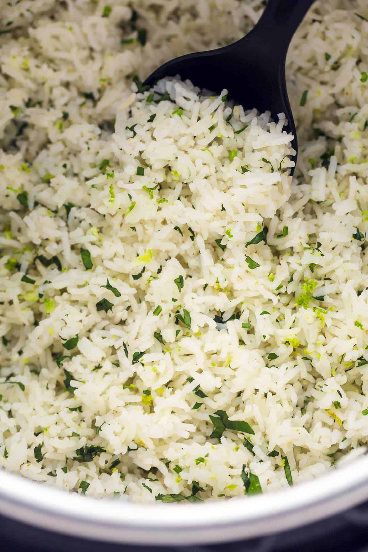 Fluffy Cilantro Lime Rice in an instant pot with a black serving spoon