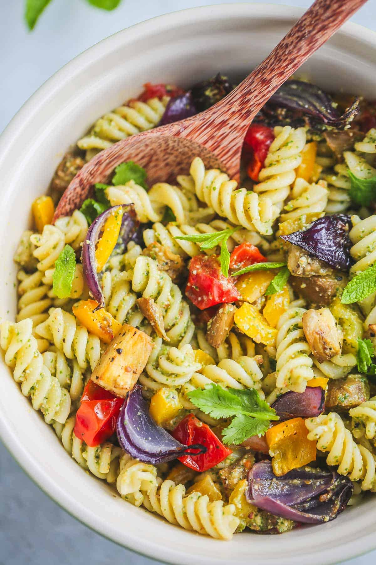 Vegan Pasta Salad served in a bowl, with a serving wooden spoon