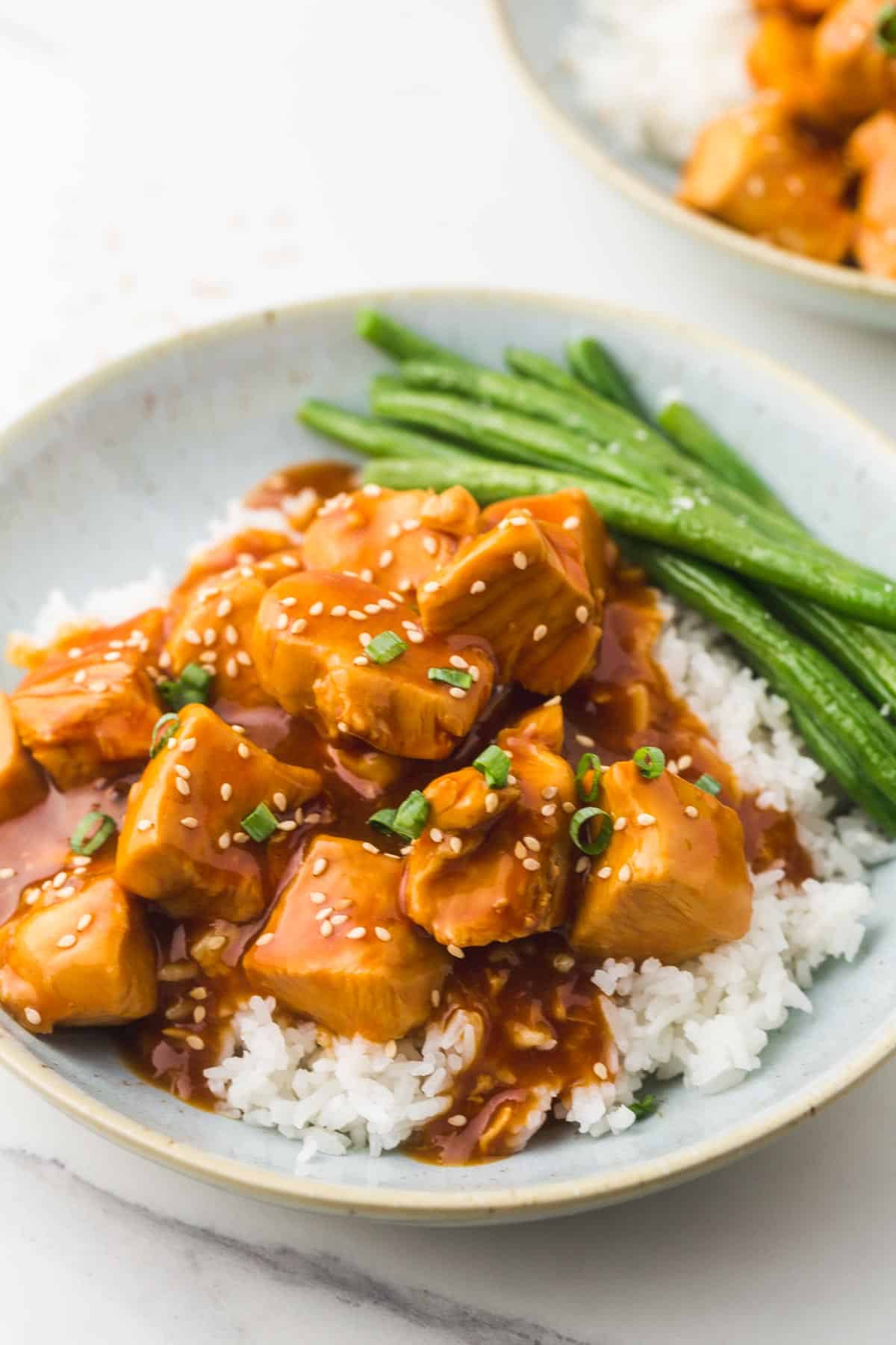 Instant Pot Honey Garlic Chicken in a bowl, served over jasmine rice, and green beans on the side