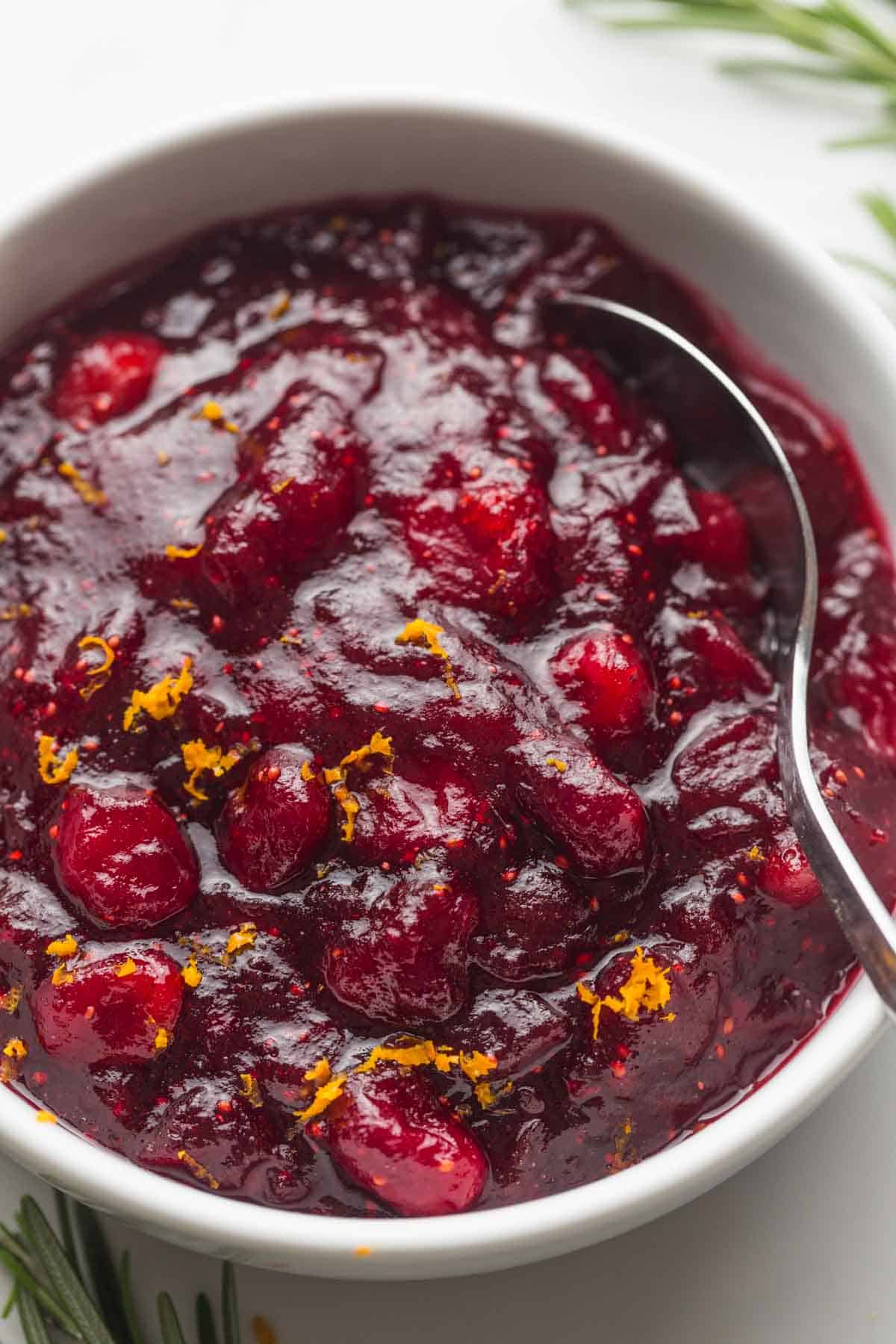 Close up shot of cranberry sauce with orange zest served in a white bowl