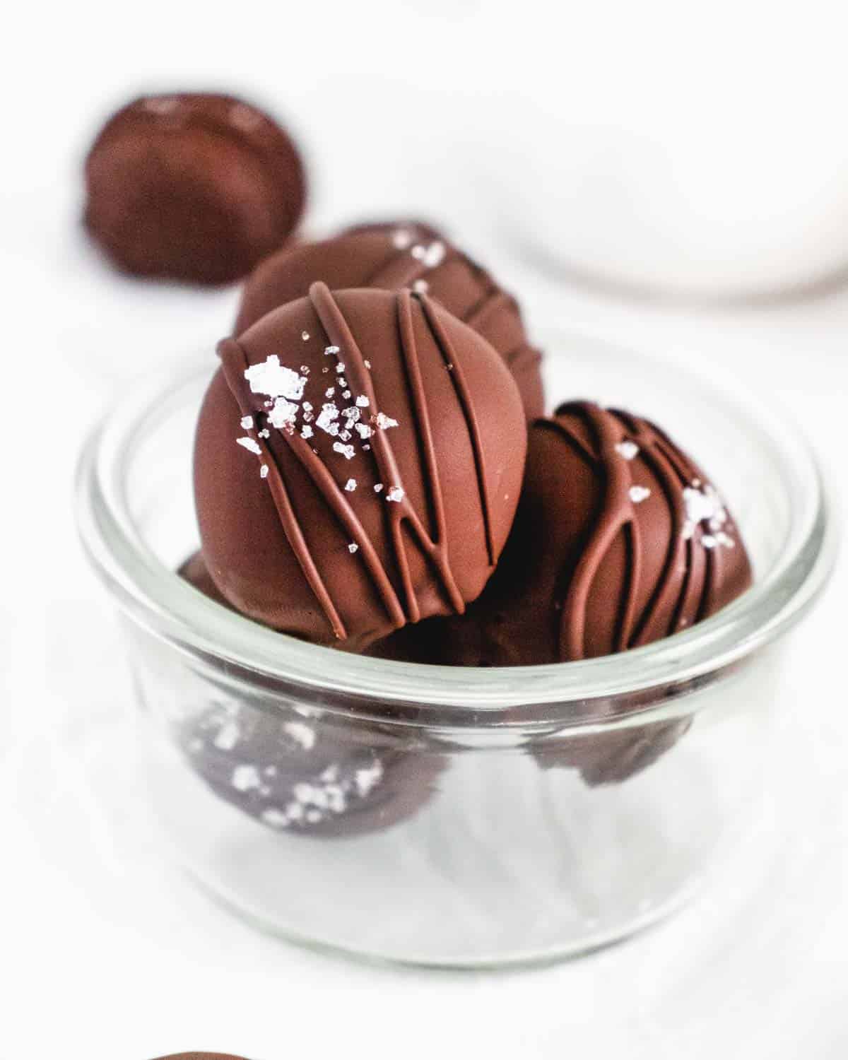 Close up photo of homemade Chocolate Truffles topped with sea salt and a drizzle of chocolate