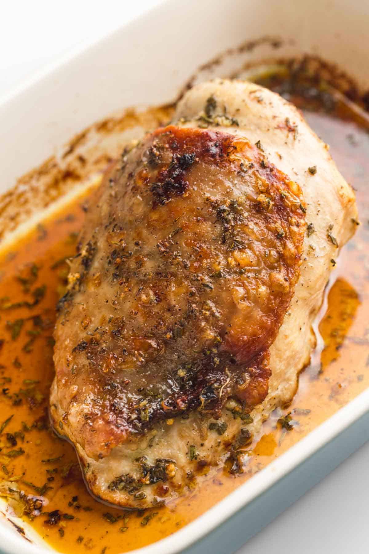 A roasted turkey breast in a baking pan