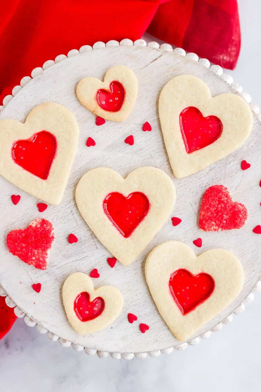 Heart shaped stained glass cookies with red melted candy in the middle