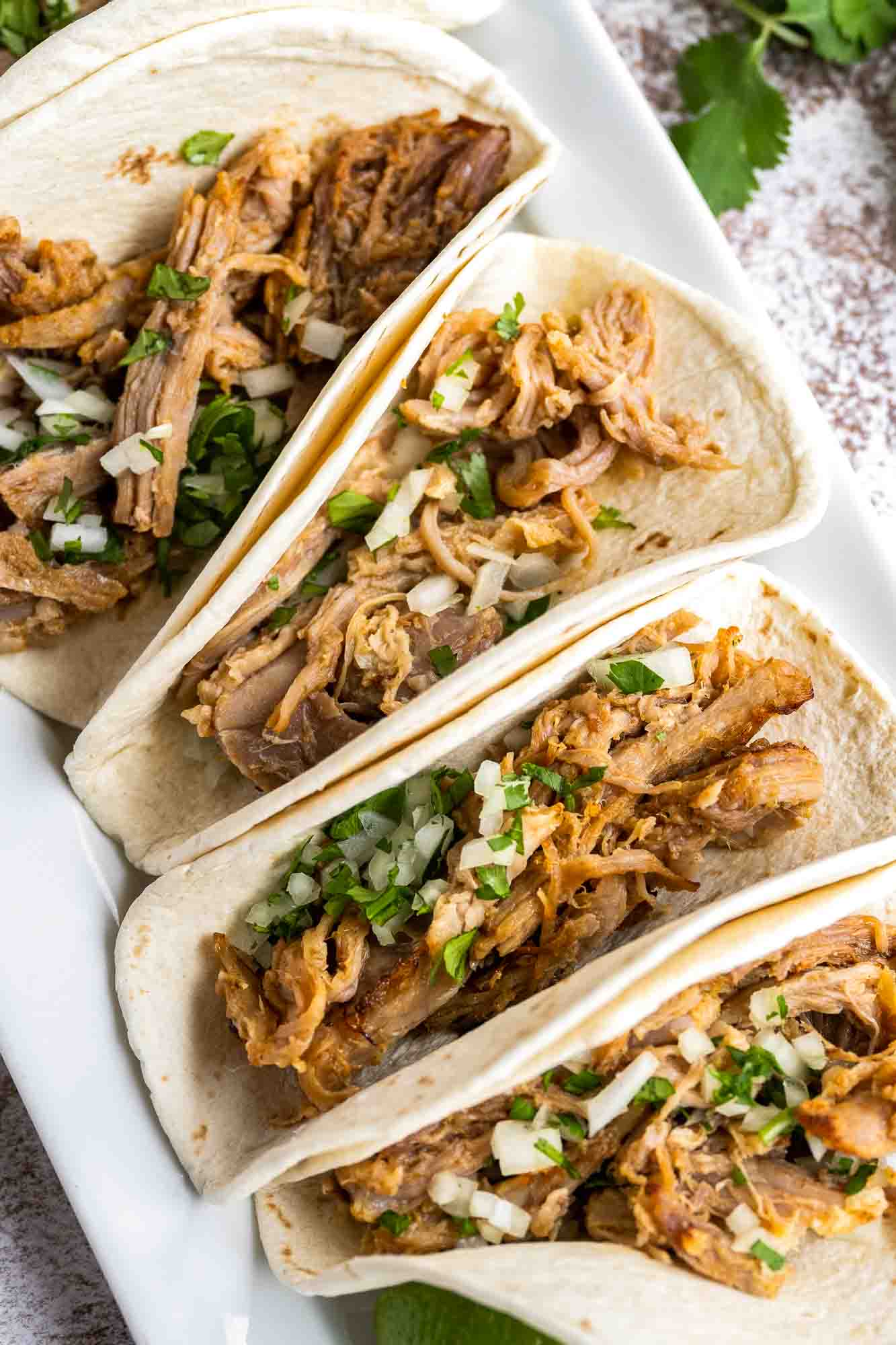 Carnitas tacos in a white platter