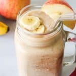 Apple banana smoothie served in a large glass jar, with a glass straw