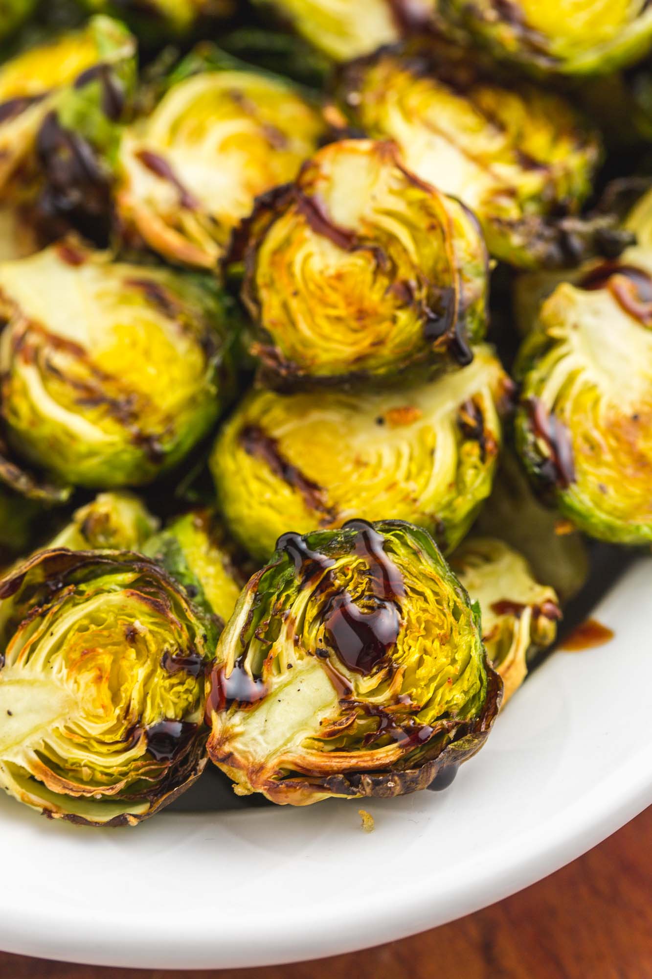 Close up shot of air fried brussels sprouts with a drizzle of balsamic glaze