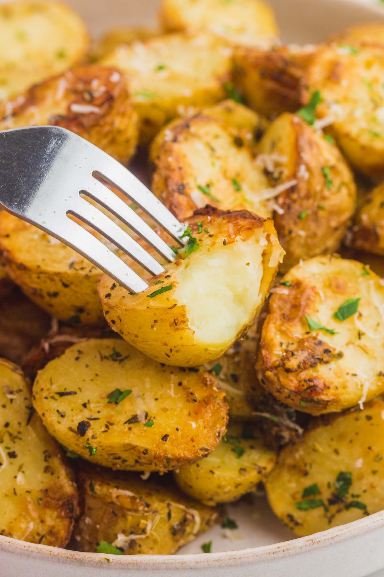 A bite shot of roasted potatoes with a fork