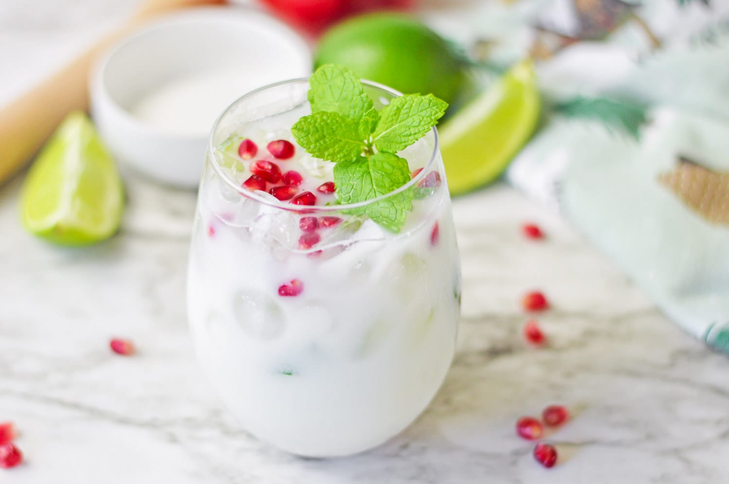 White christmas mojito garnished with pomegranate arils and fresh mint leaves