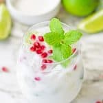 White christmas mojito garnished with pomegranate arils and fresh mint leaves