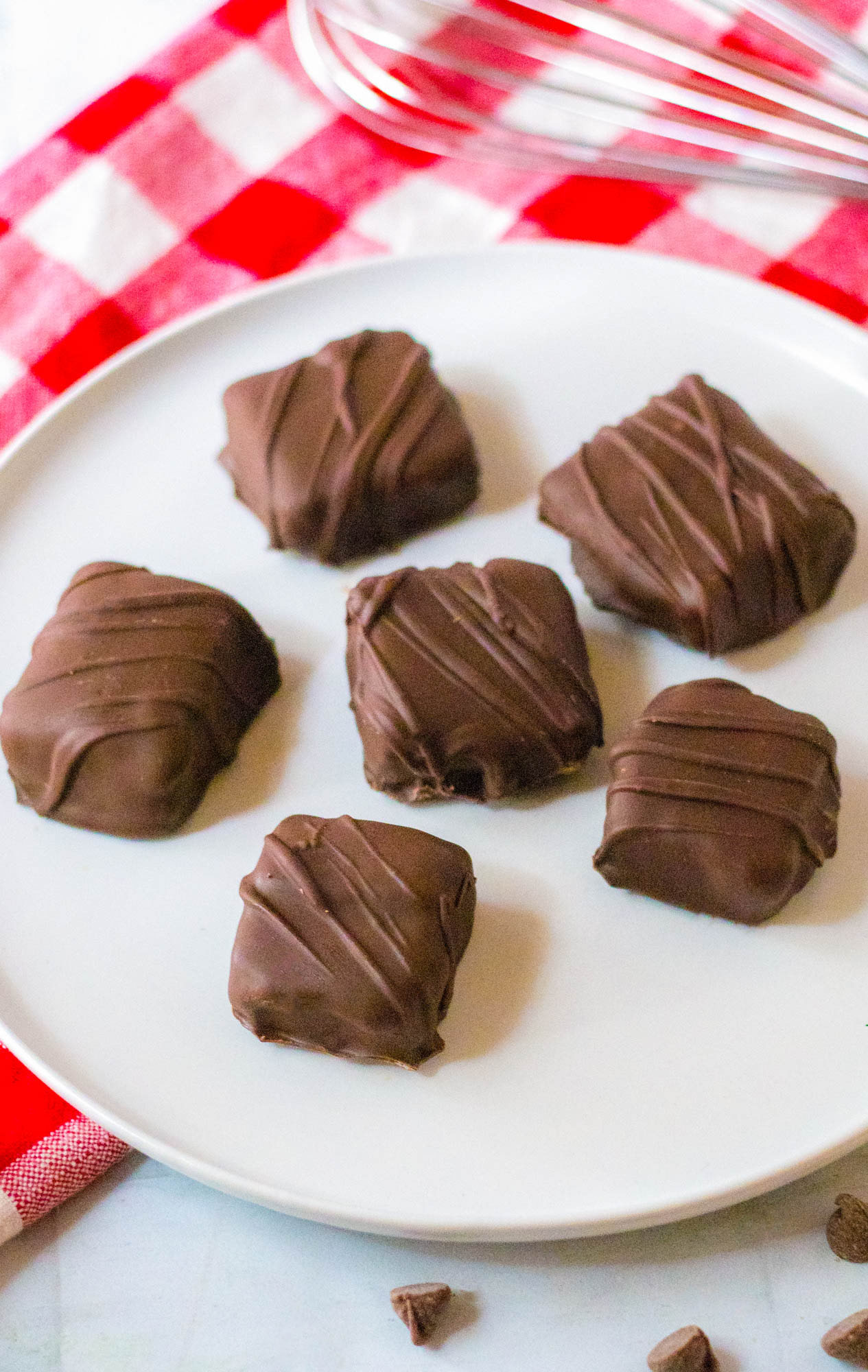 Three Musketeers candy drizzled with melted chocolate served on a white plate. 