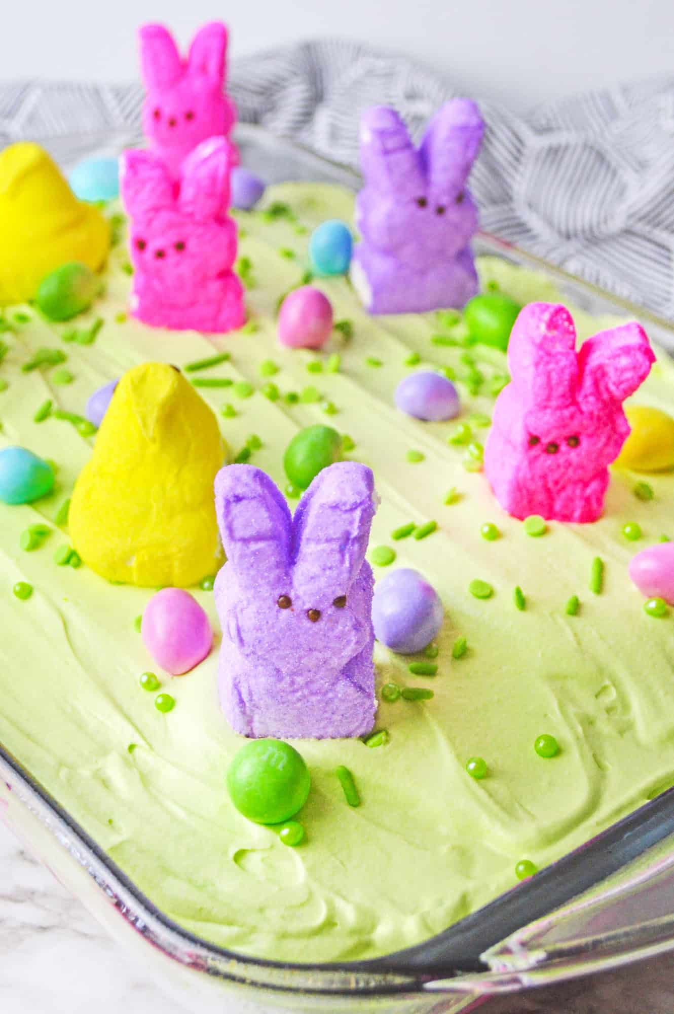 Easter poke cake with peeps, in a 9x13 inch glass pan.