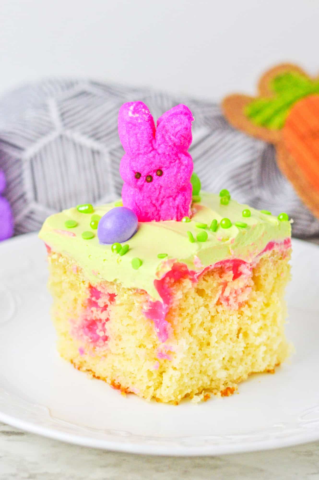 A slice of vanilla poke cake with easter peep and an easter egg