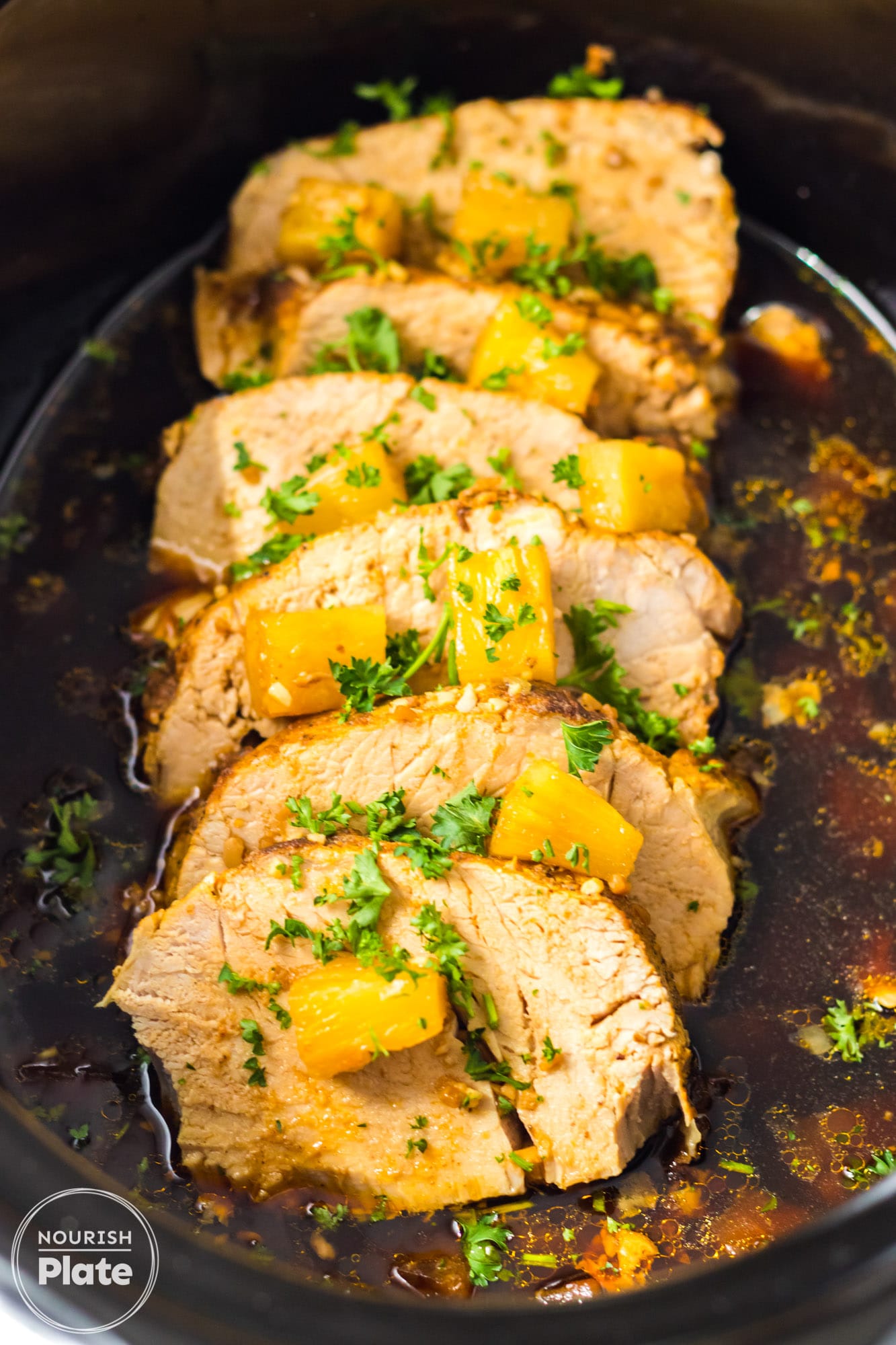 Sliced Pineapple Pork Loin with pineapple chunks in the slow cooker