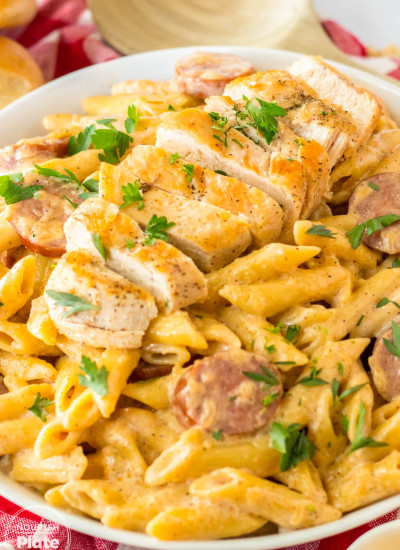 Cajun Chicken Alfredo made with penne pasta, and sliced chicken, plated.