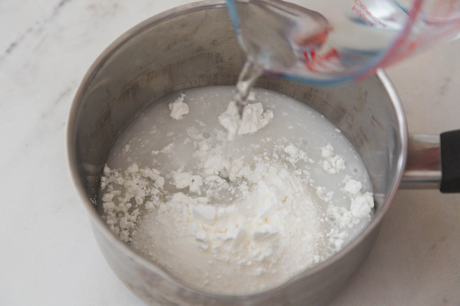 Combining water with cornstarch and sugar in a saucepan