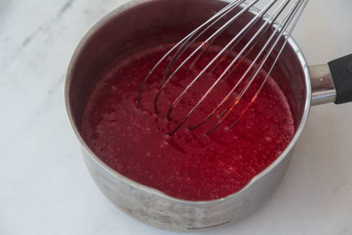Mixing the strawberry gelatine in a saucepan