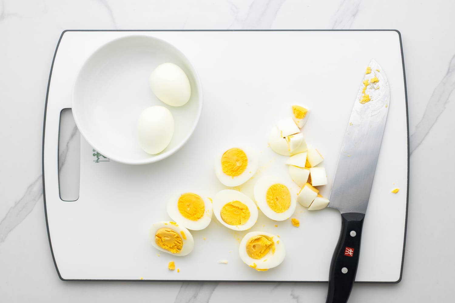 Chopping eggs on a white cutting board
