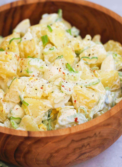 Close up shot of potato salad in a wooden bowl
