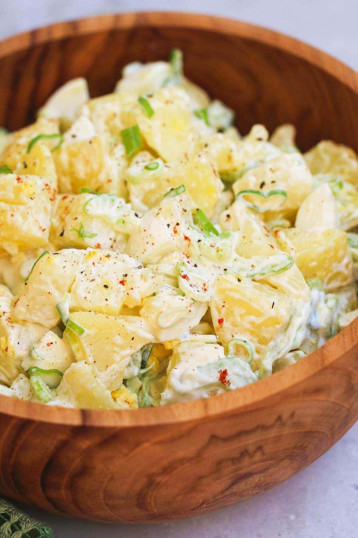 Close up shot of potato salad in a wooden bowl