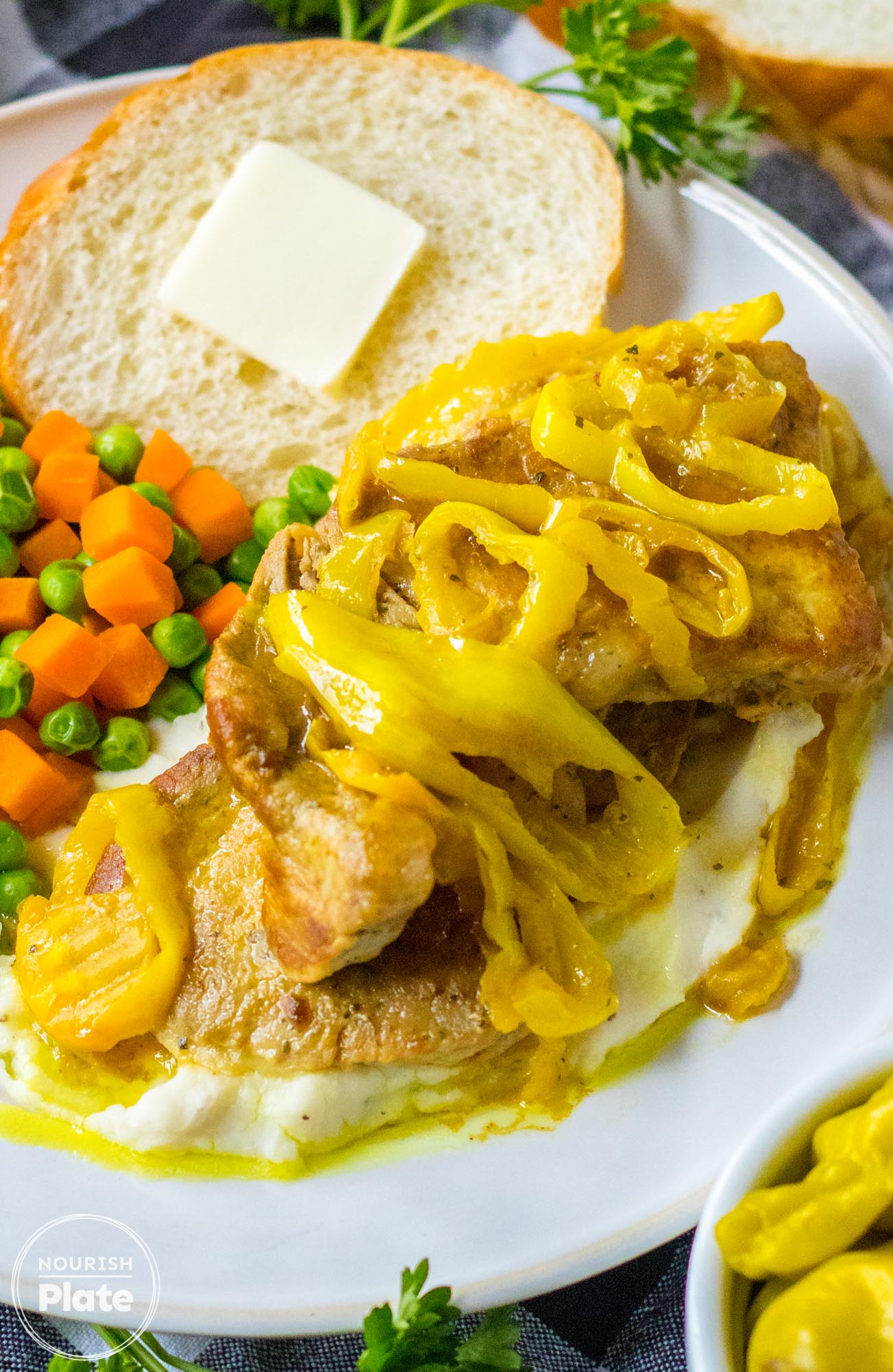 Mississippi pork chops plated with steamed vegetables and toast with butter