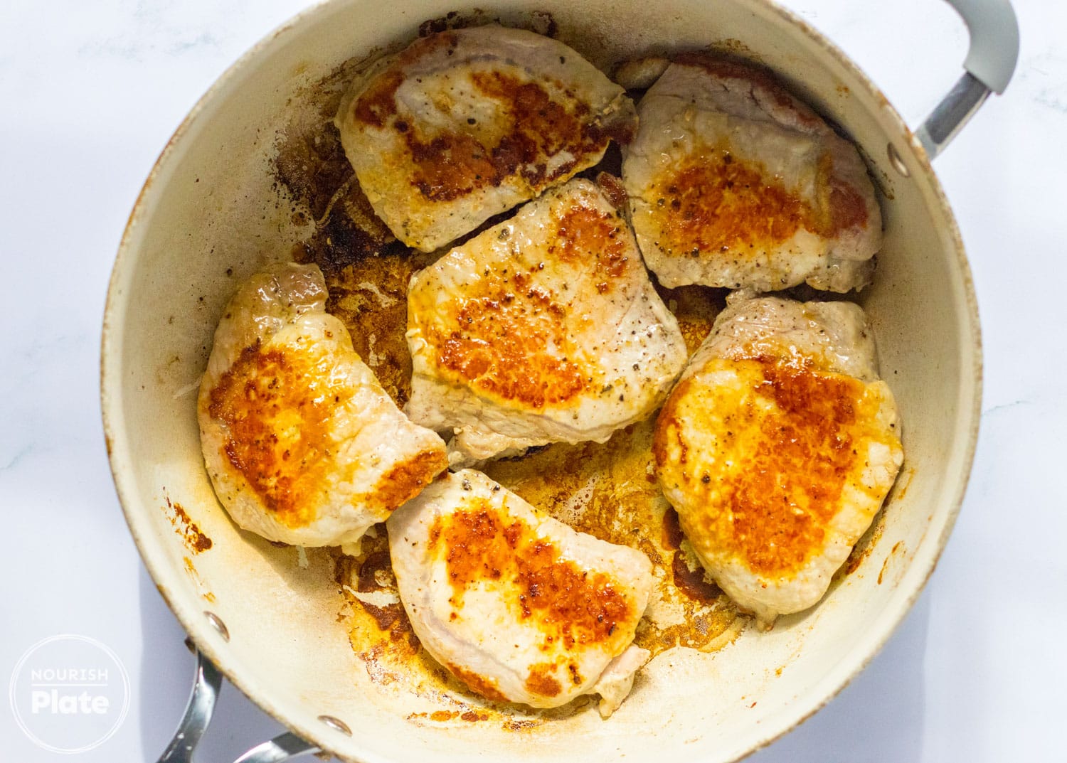 Browned pork chops in a frying pan