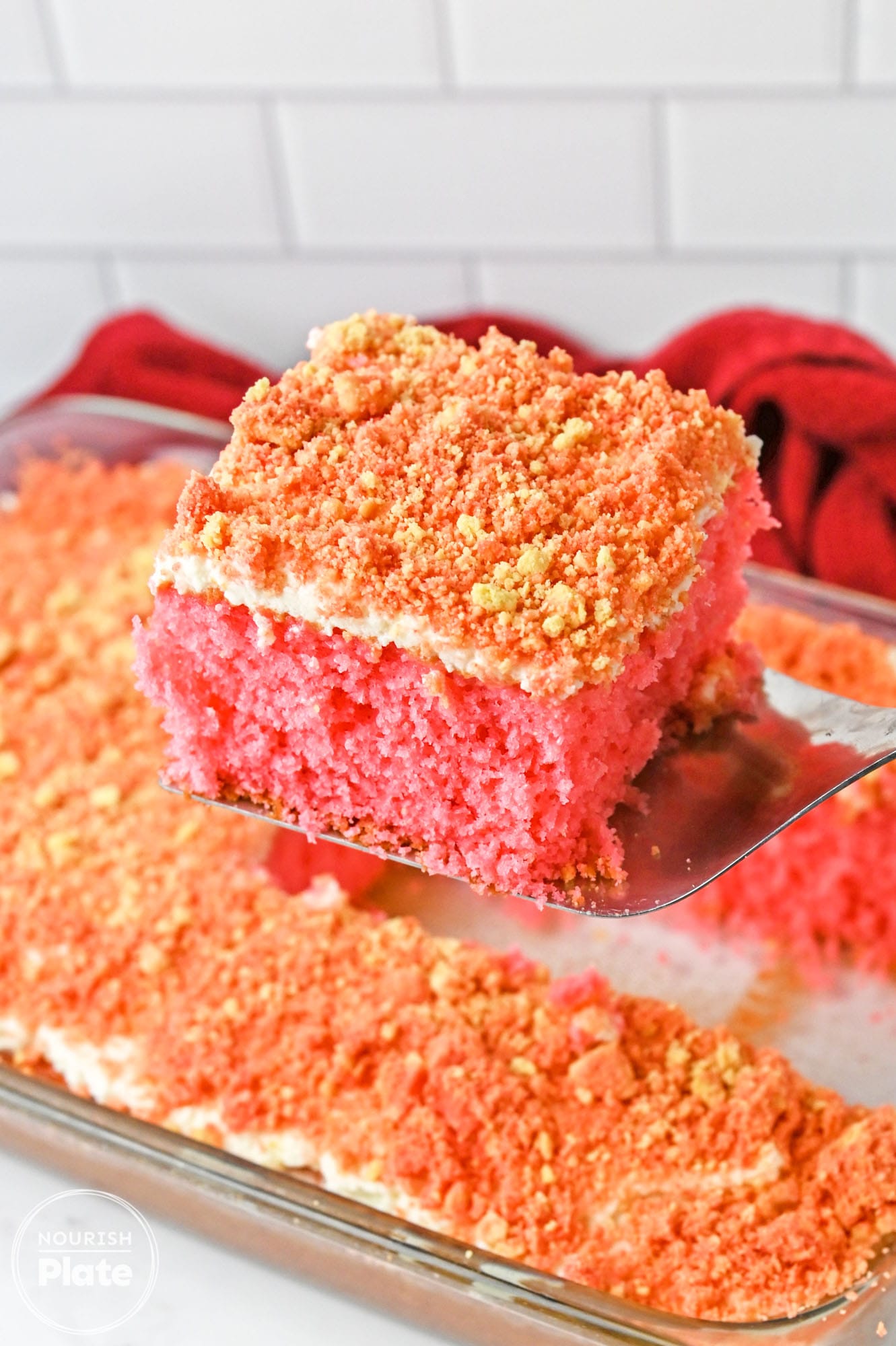 Taking a slice of strawberry crunch cake from the cake pan