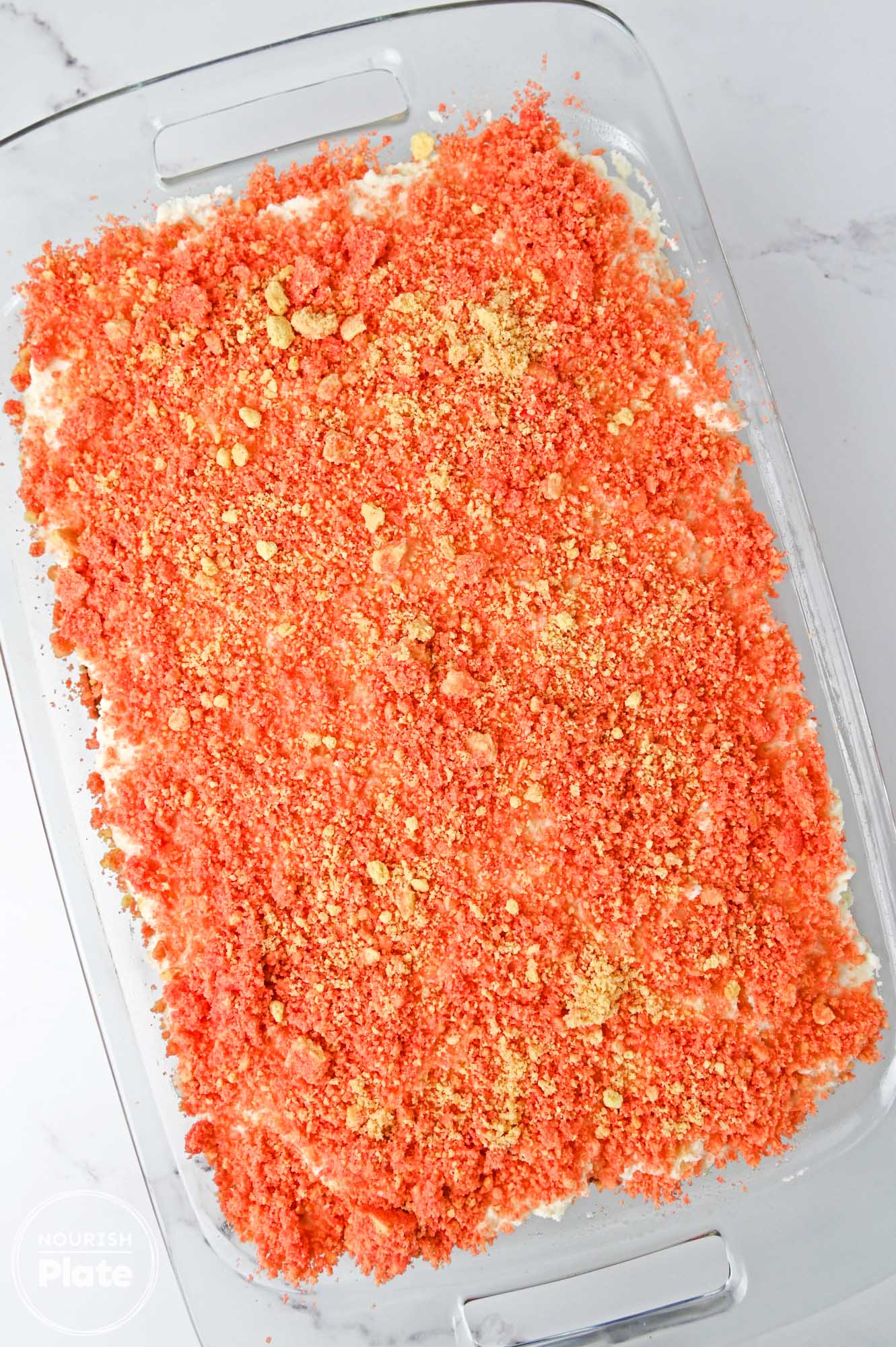Overhead shot of strawberry crunch cake in a glass 9x13 inch pan