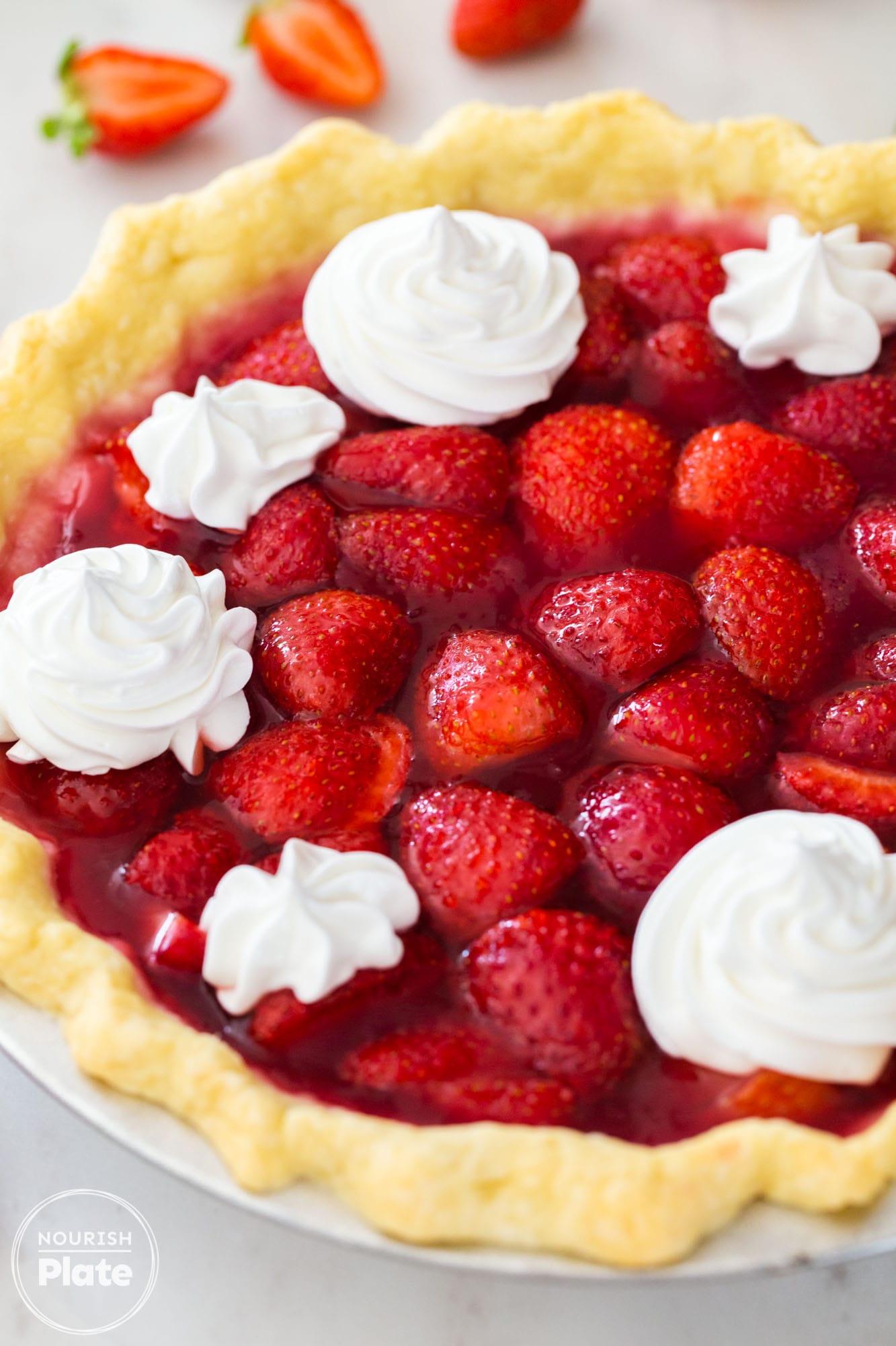 Angle shot of a fresh strawberry pie with fresh whipped cream decorations
