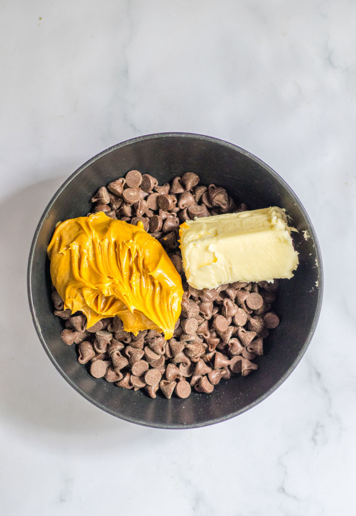 Chocolate chips, peanut butter, and butter in a black bowl