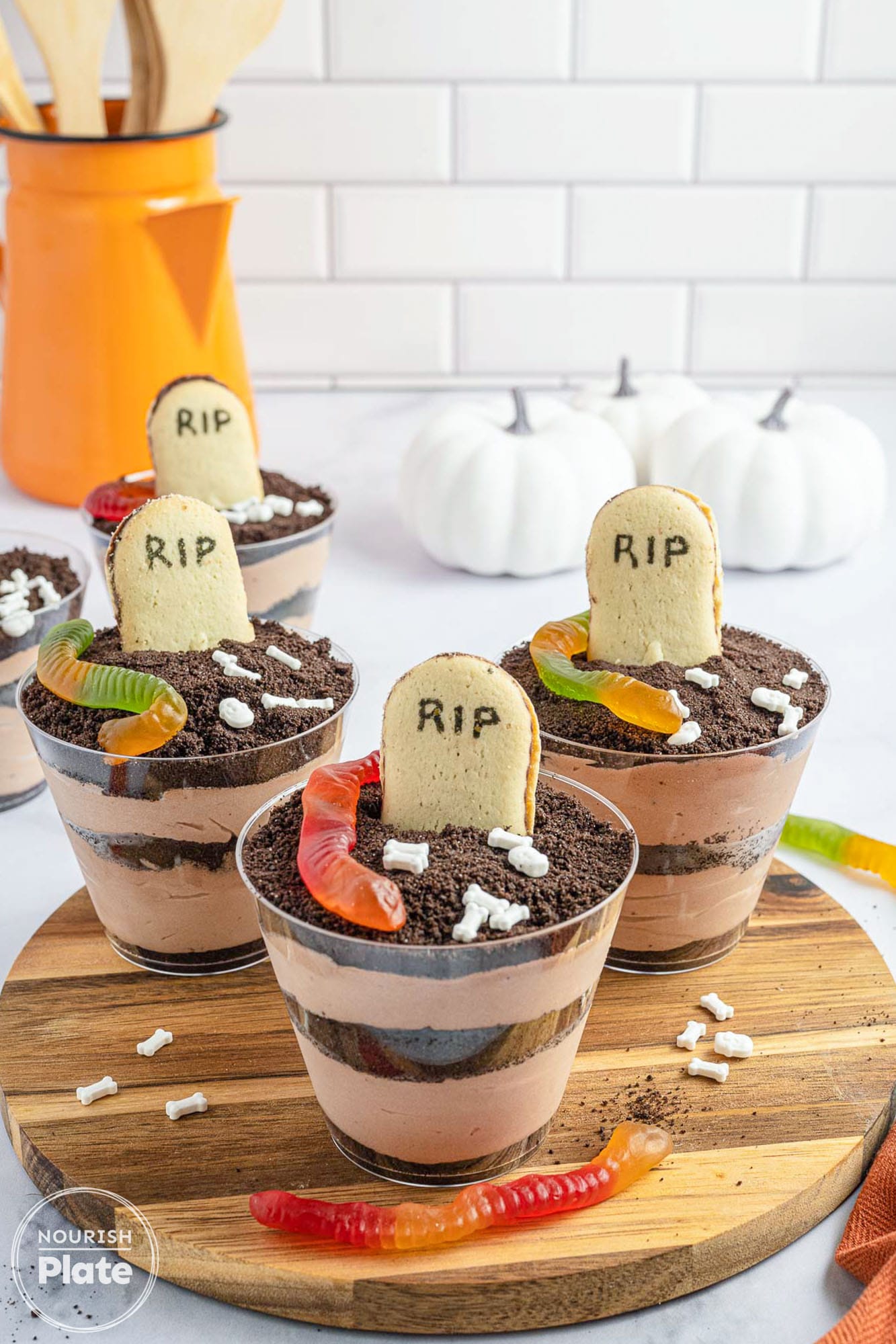 3 dirt cups on a wooden tray, decorated for halloween