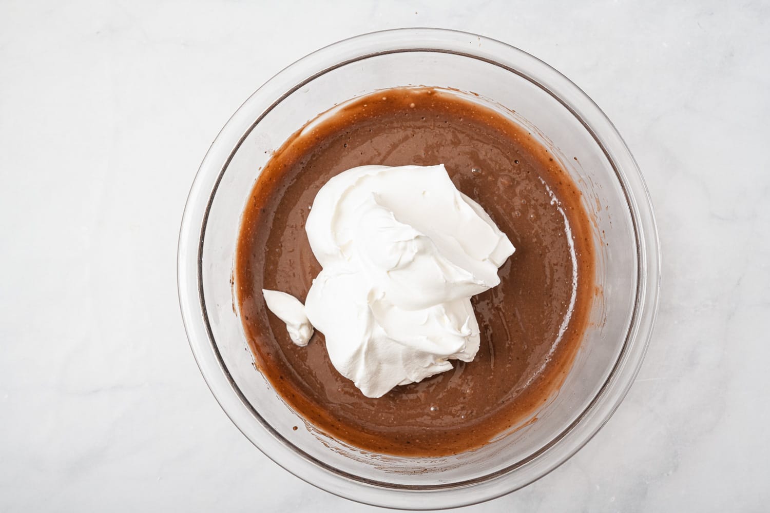 Whipped topping added to a bowl of chocolate pudding