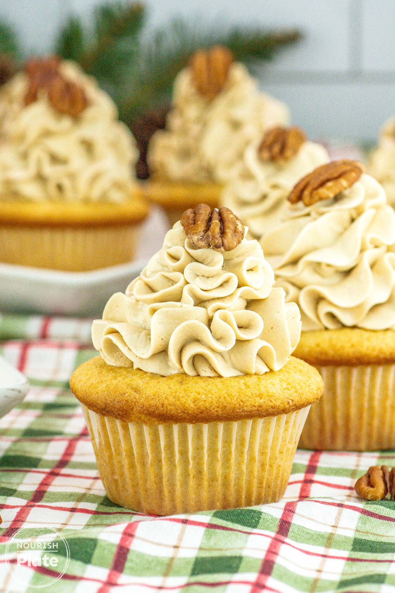 Pecan pie cupcakes frosted with buttercream and topped with a pecan half