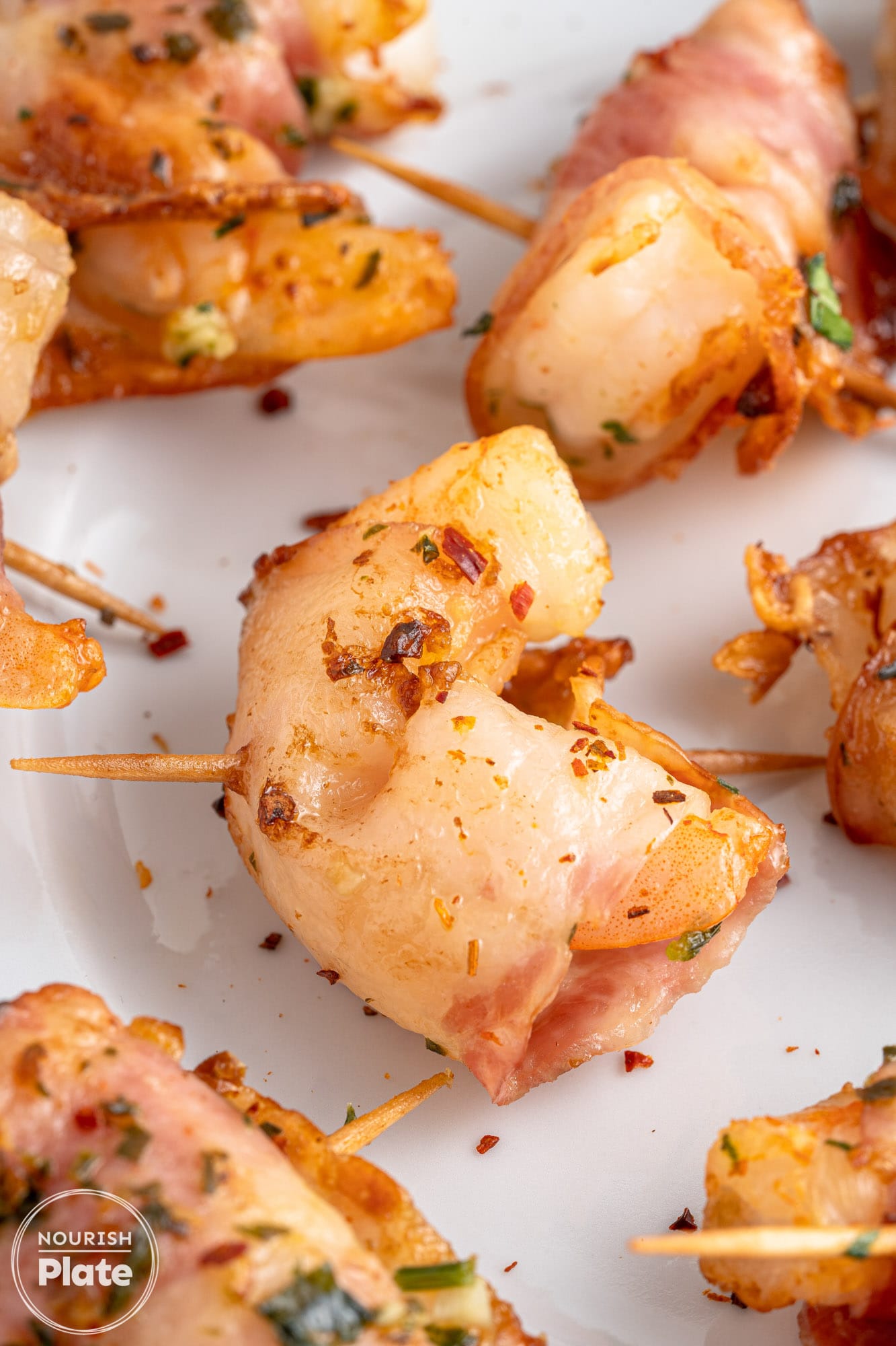 Close up shot of bacon wrapped shrimp, sealed with skewers