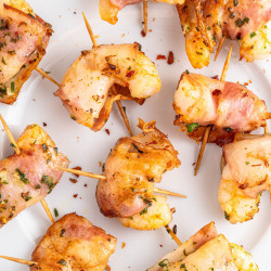 Overhead shot of bacon wrapped shrimp on a white plate