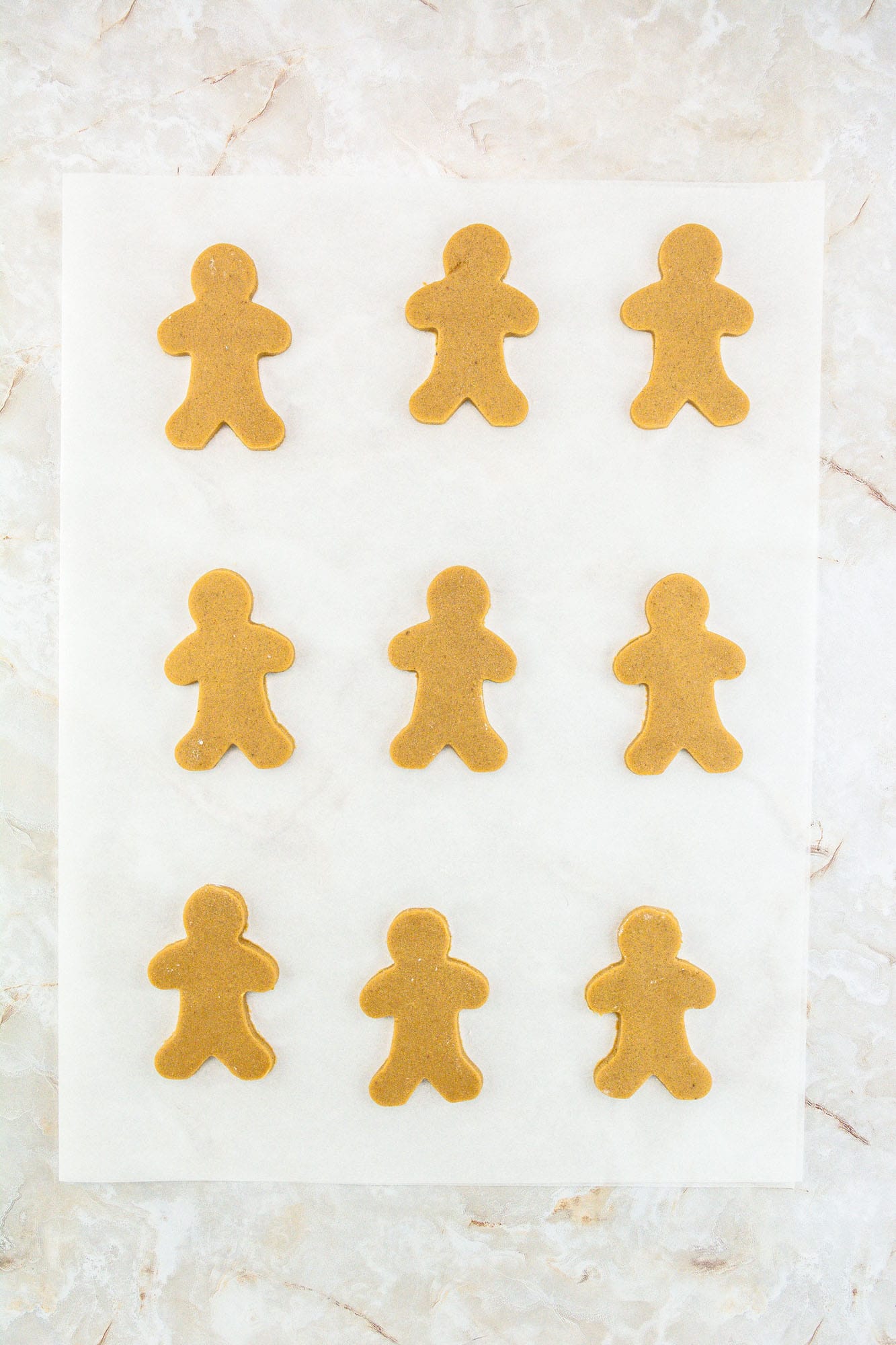Gingerbread men cookies on parchment paper before baking