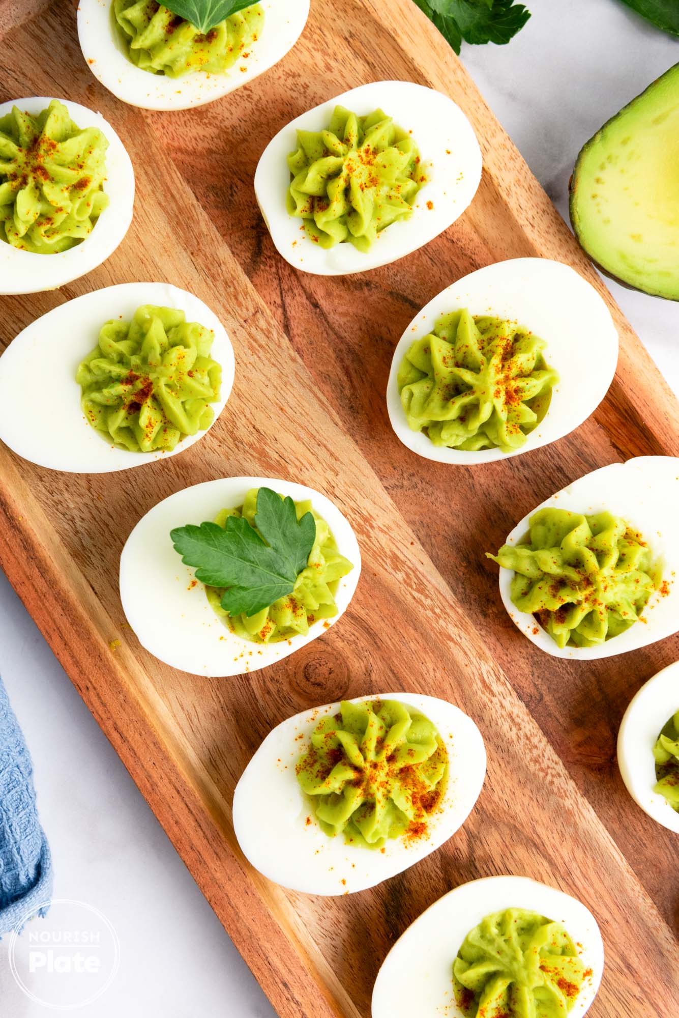 Overhead shot of avocado deviled eggs placed on a wooden tray