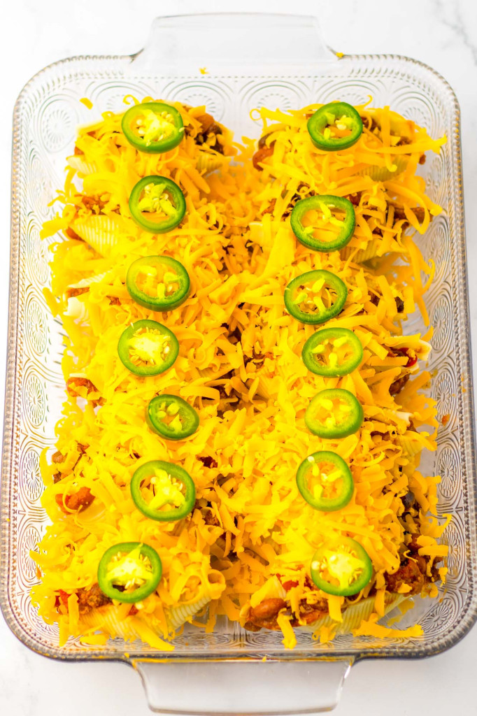 Beef stuffed shells topped with cheese in a 9x13 pan before baking