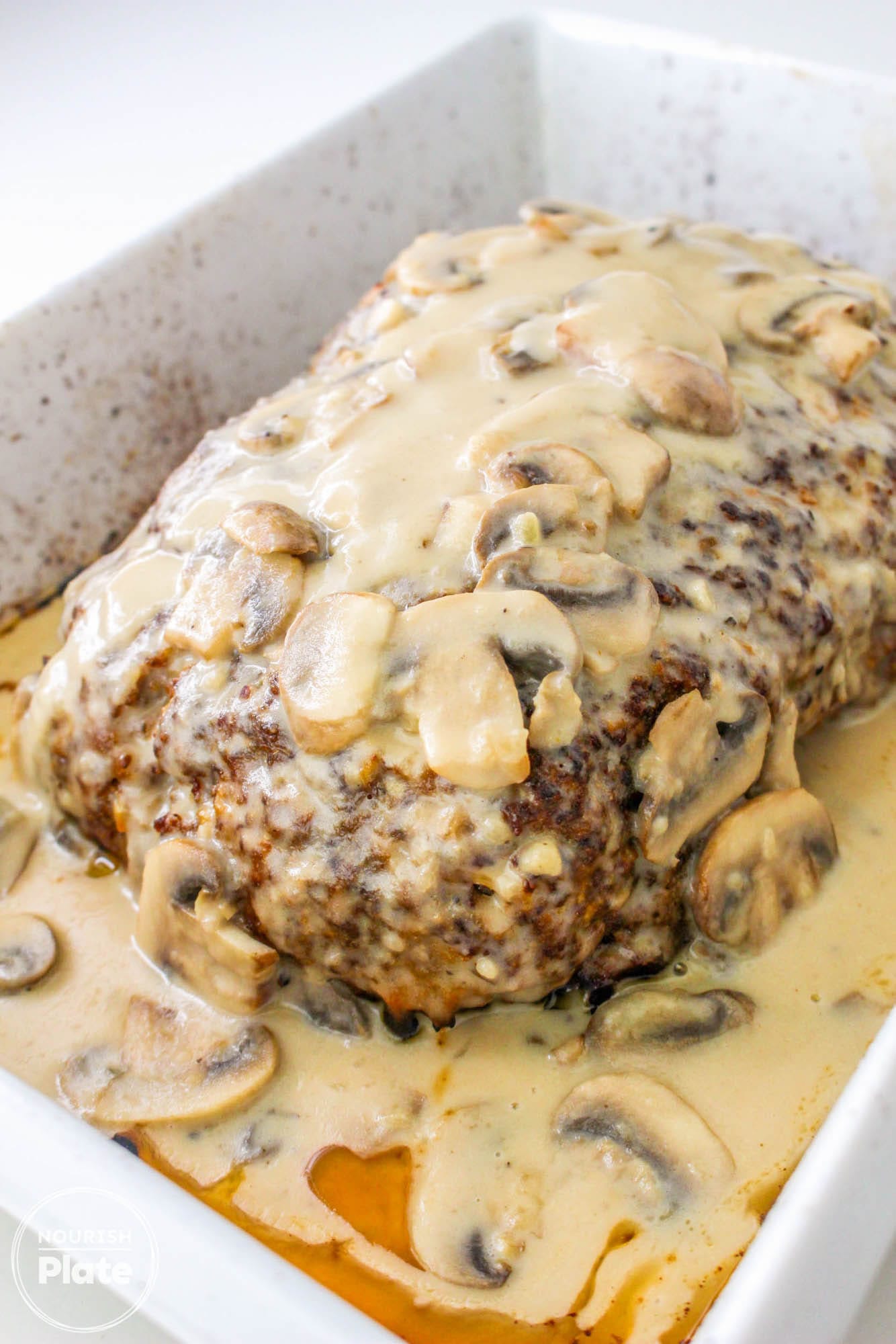 Mushroom meatloaf with gravy in a white baking dish
