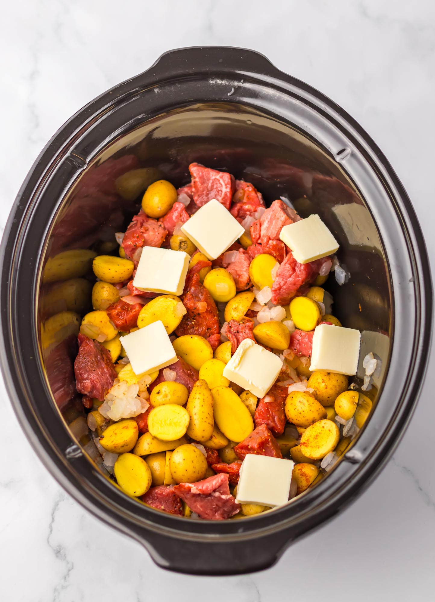 Steak, potatoes and butter in a slow cooker